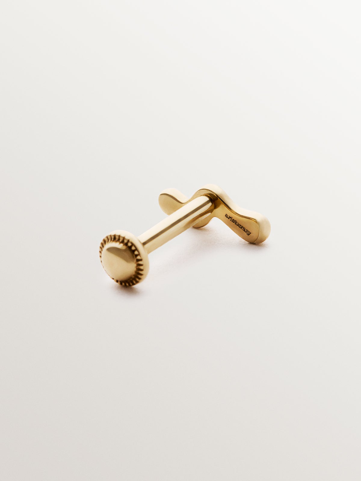 Piercing individual de oro amarillo de 18K con forma orgánica de ola.