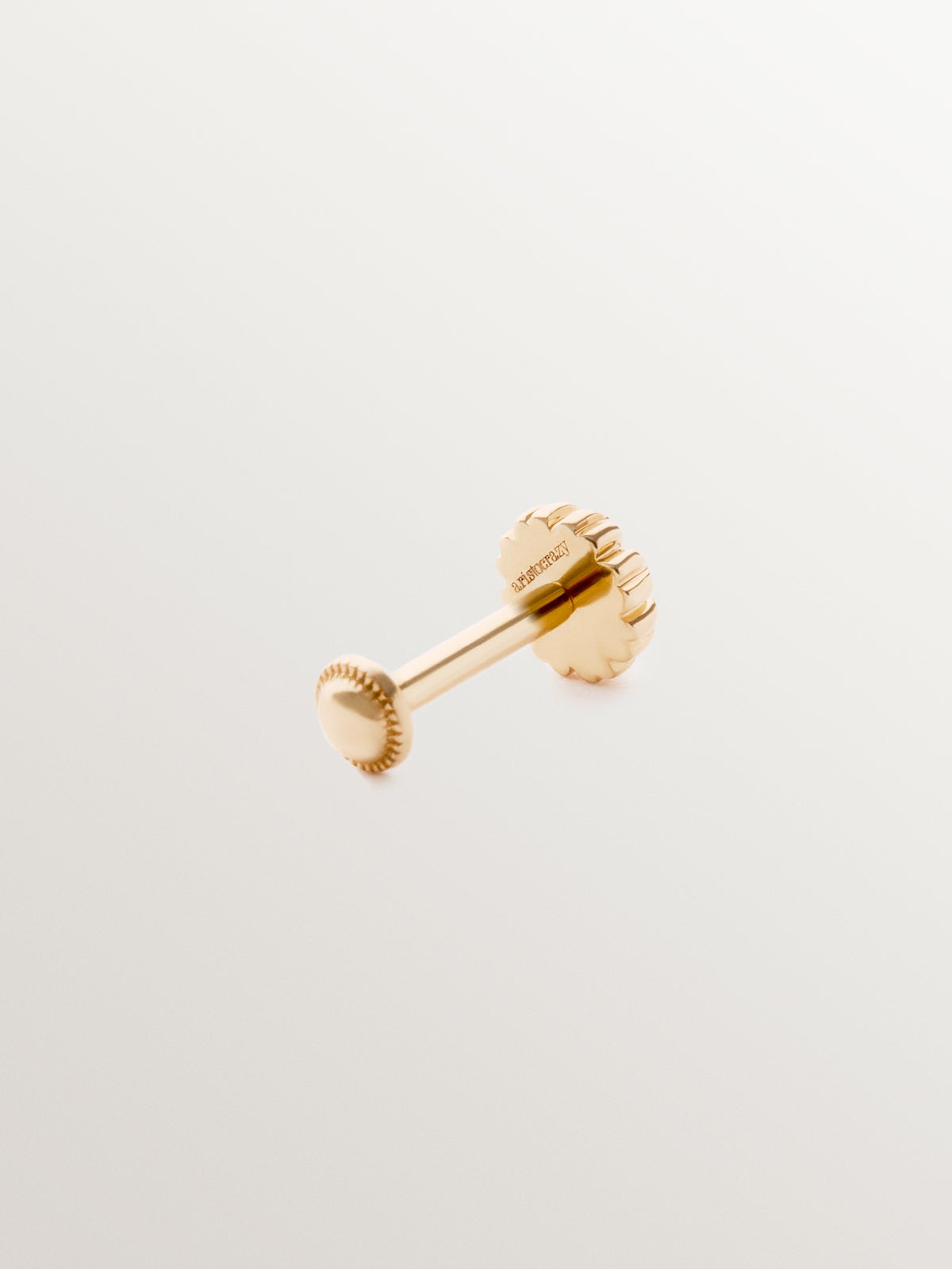 Piercing individual de oro amarillo de 18K con rodolita central rosa en talla brillante.