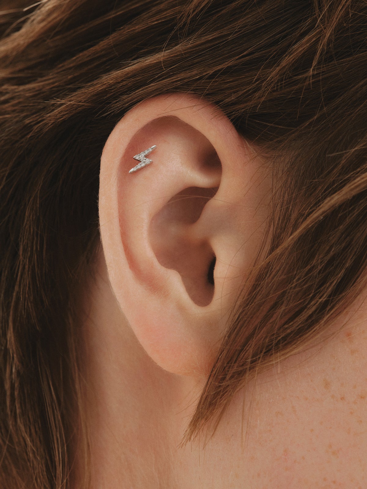 Piercing de oro blanco de 18K con diamantes en talla brillante y forma de rayo