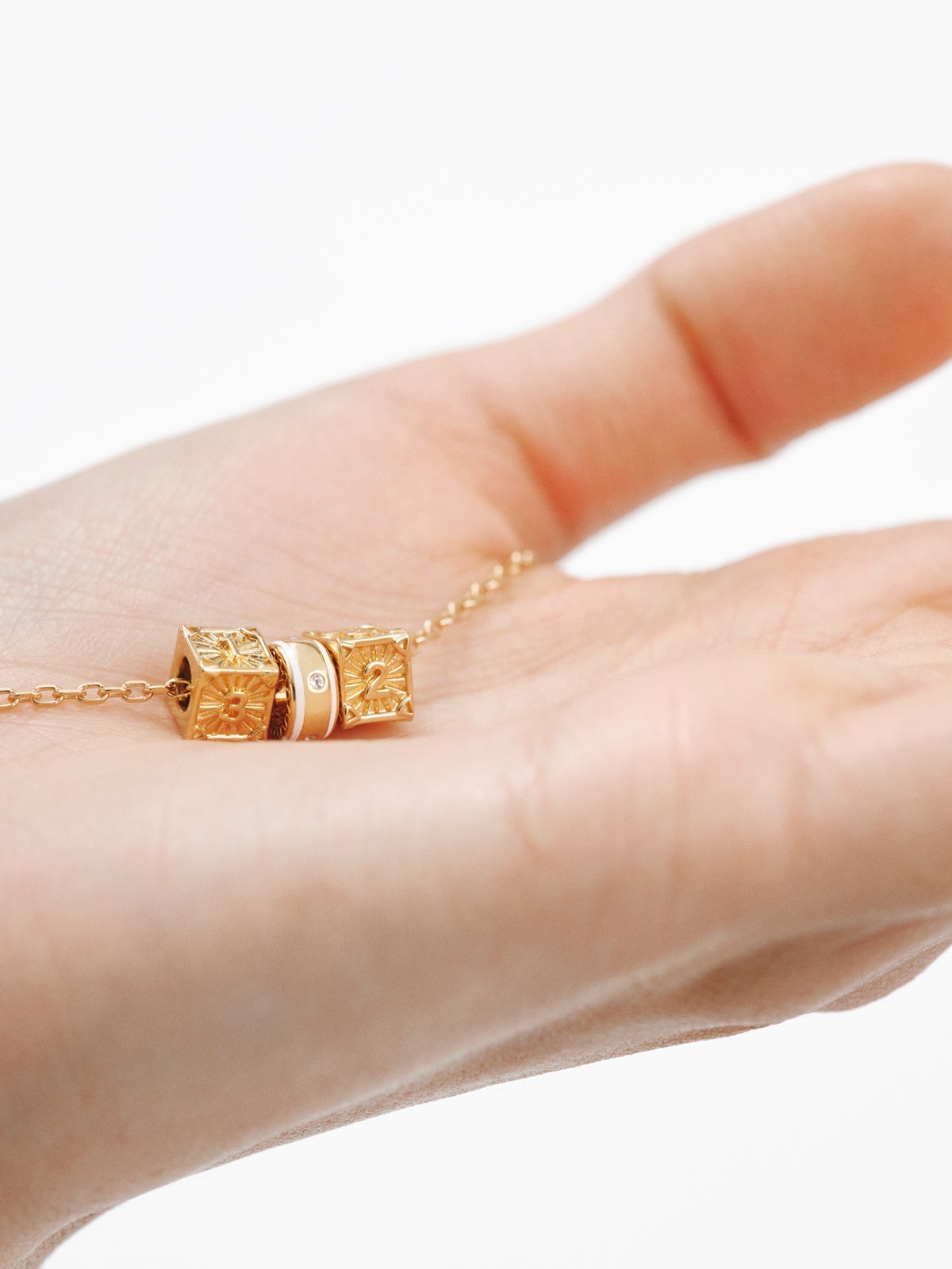 Charm de plata 925 bañada en oro amarillo de 18K con topacios blancos y esmalte blanco con forma circular