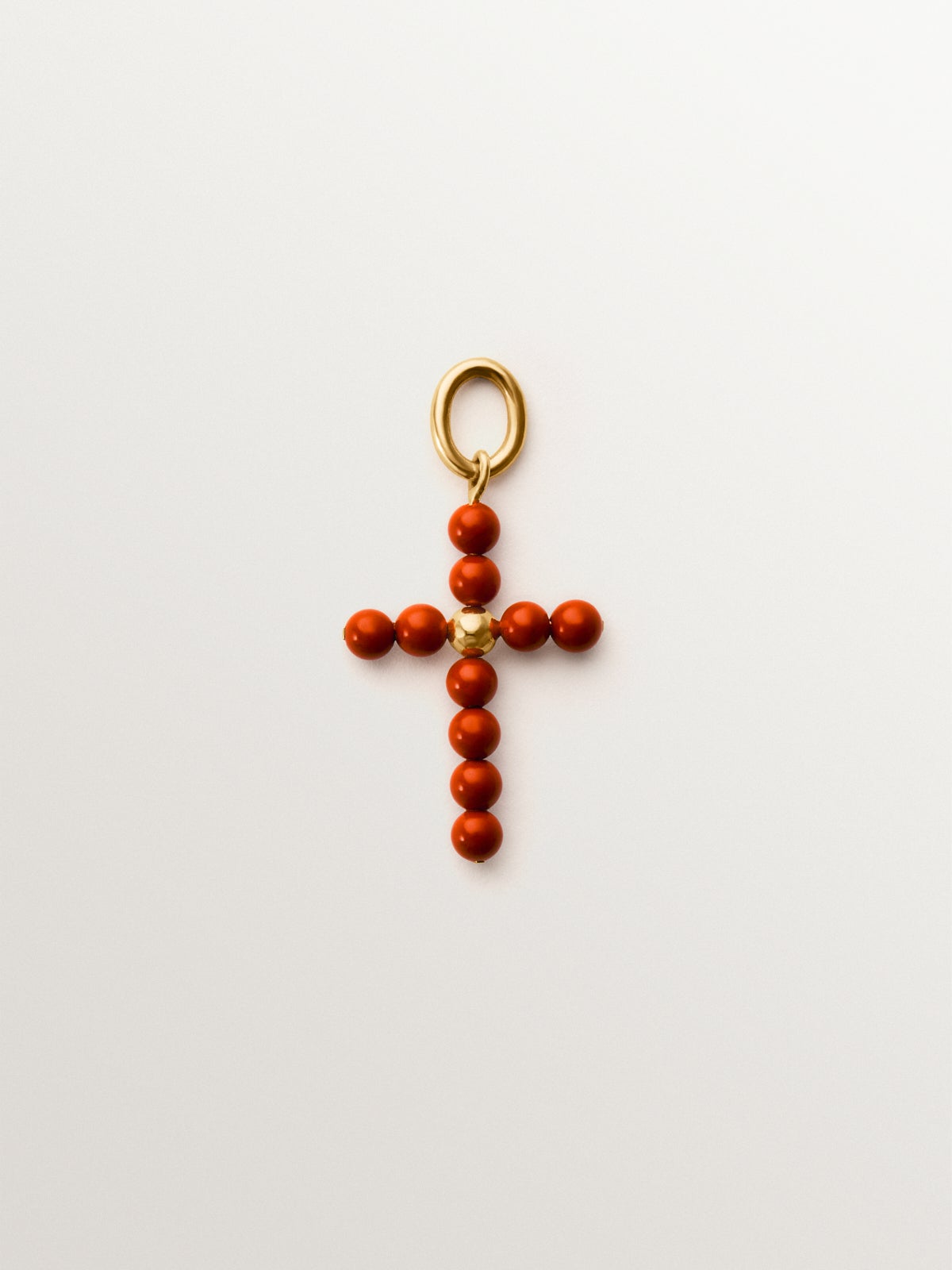 Charm de plata 925 bañada en oro amarillo de 18K con bolitas de coral y forma de cruz