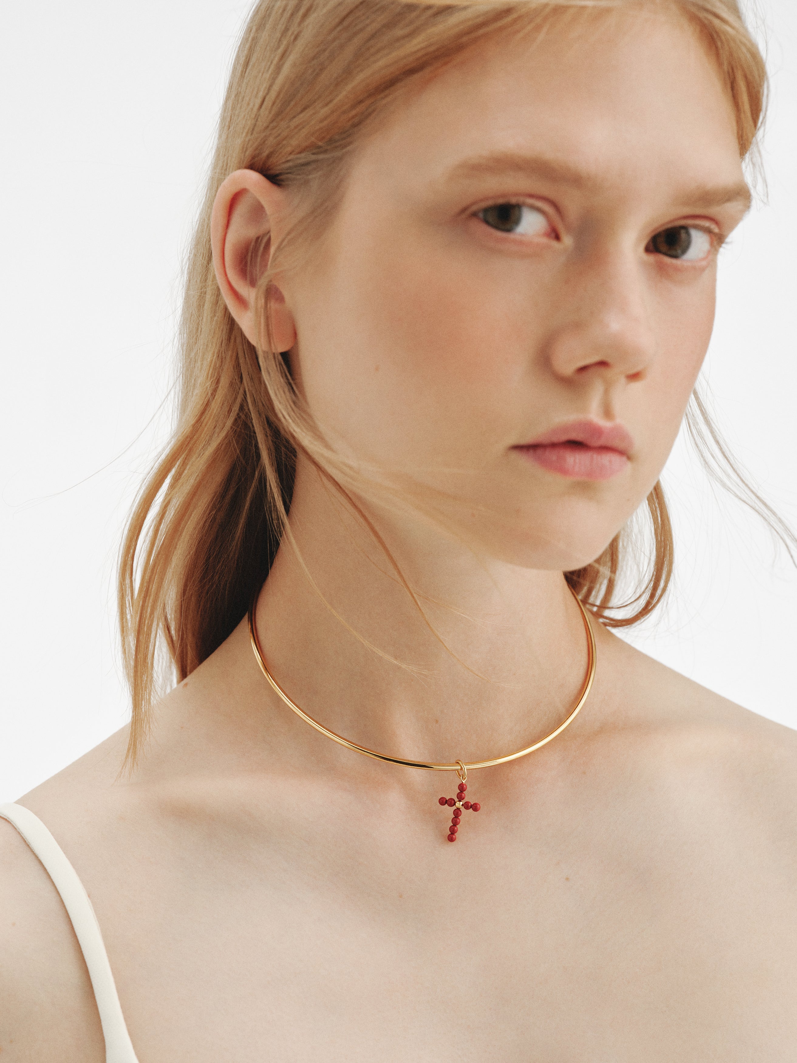 Charm de plata 925 bañada en oro amarillo de 18K con bolitas de coral y forma de cruz