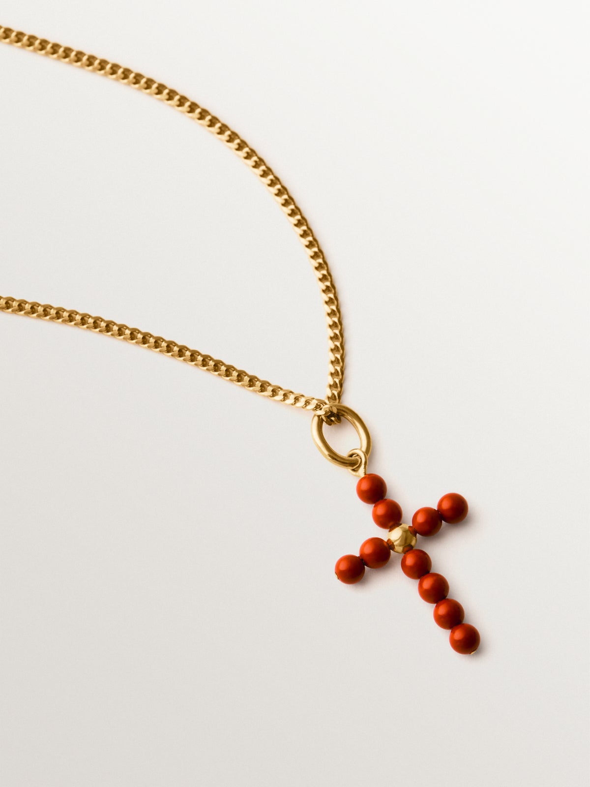 Charm de plata 925 bañada en oro amarillo de 18K con bolitas de coral y forma de cruz