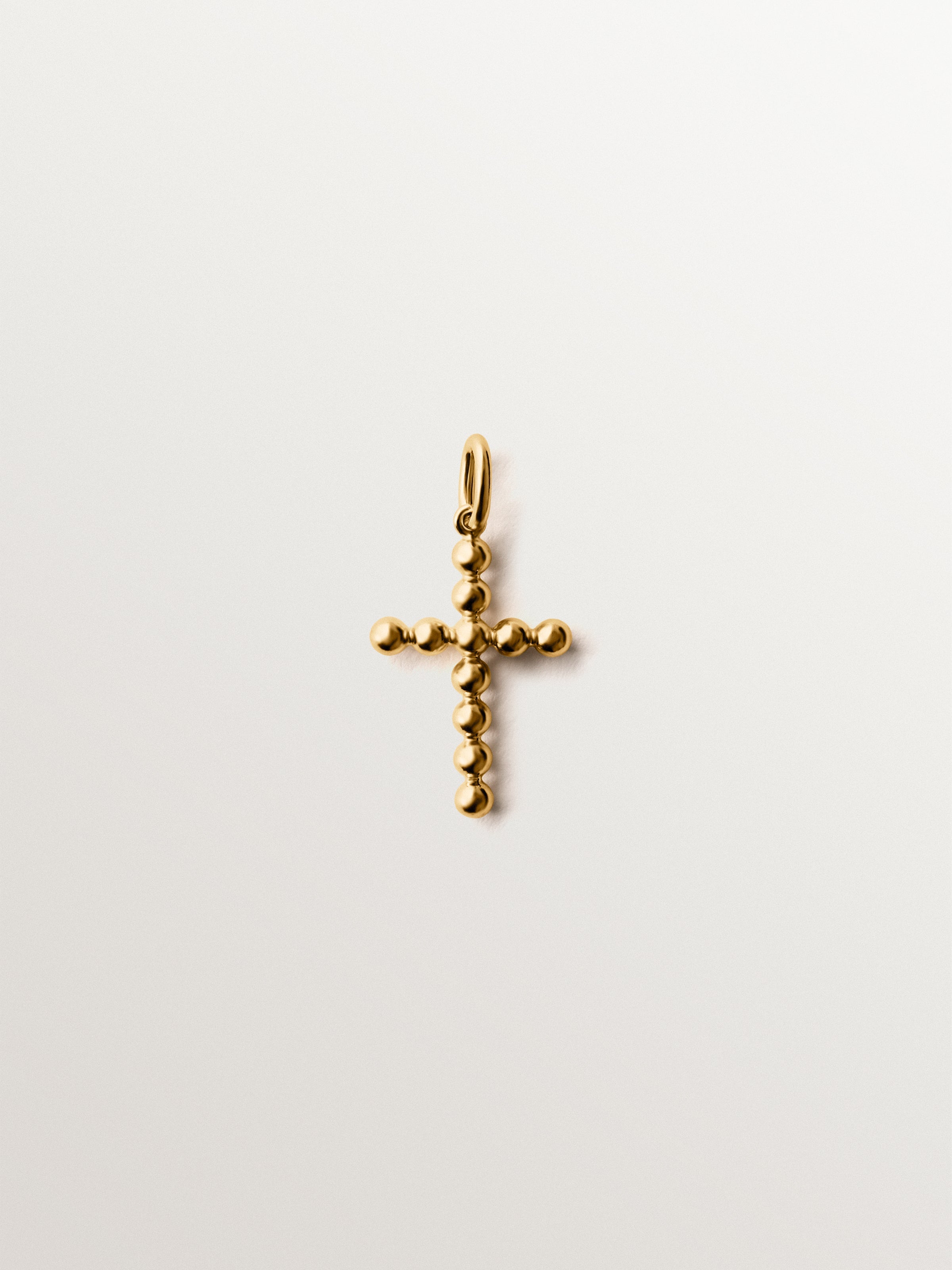 Charm de plata 925 bañada en oro amarillo de 18K con forma de cruz y motivos de esferas