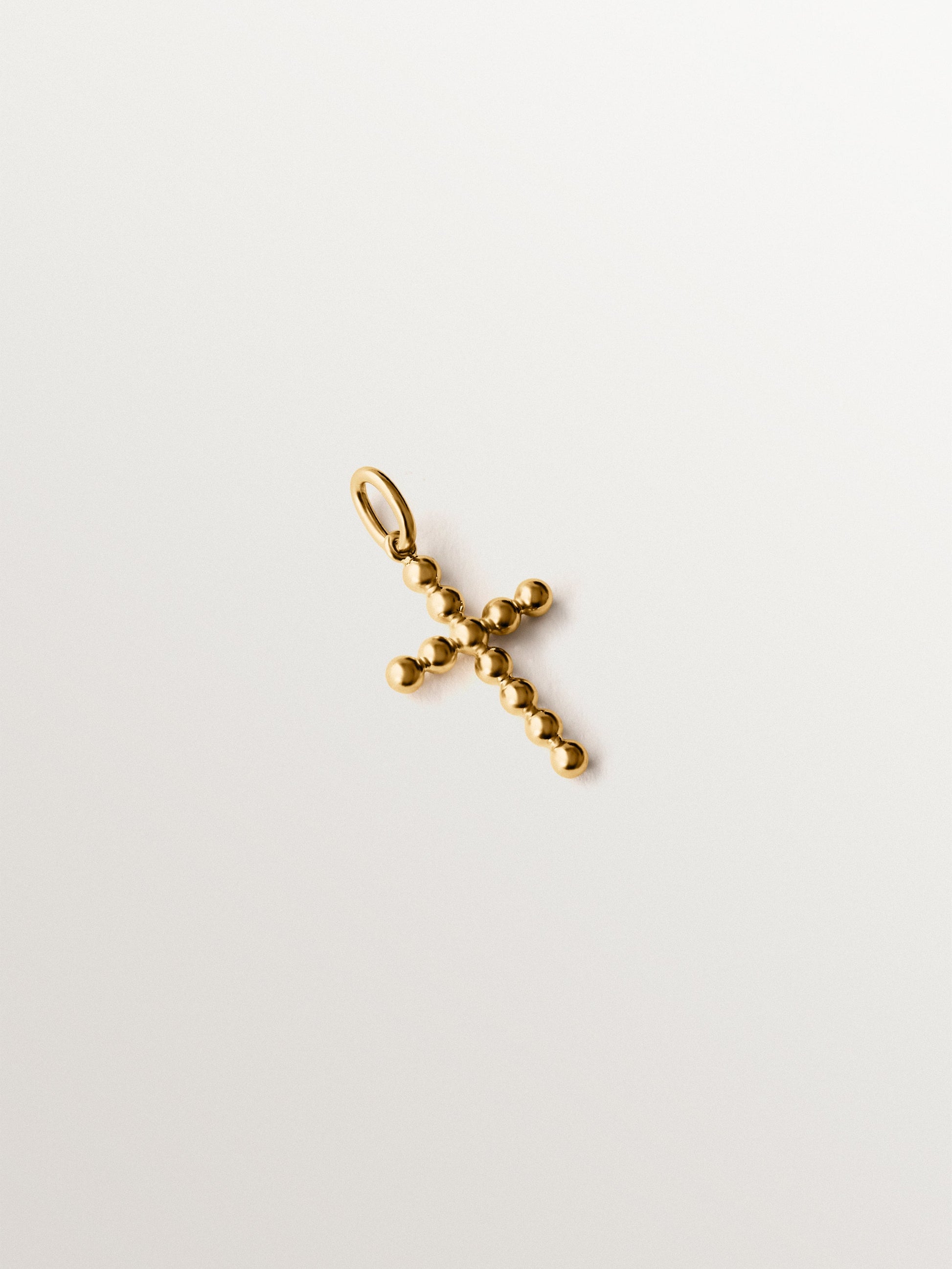 Charm de plata 925 bañada en oro amarillo de 18K con forma de cruz y motivos de esferas