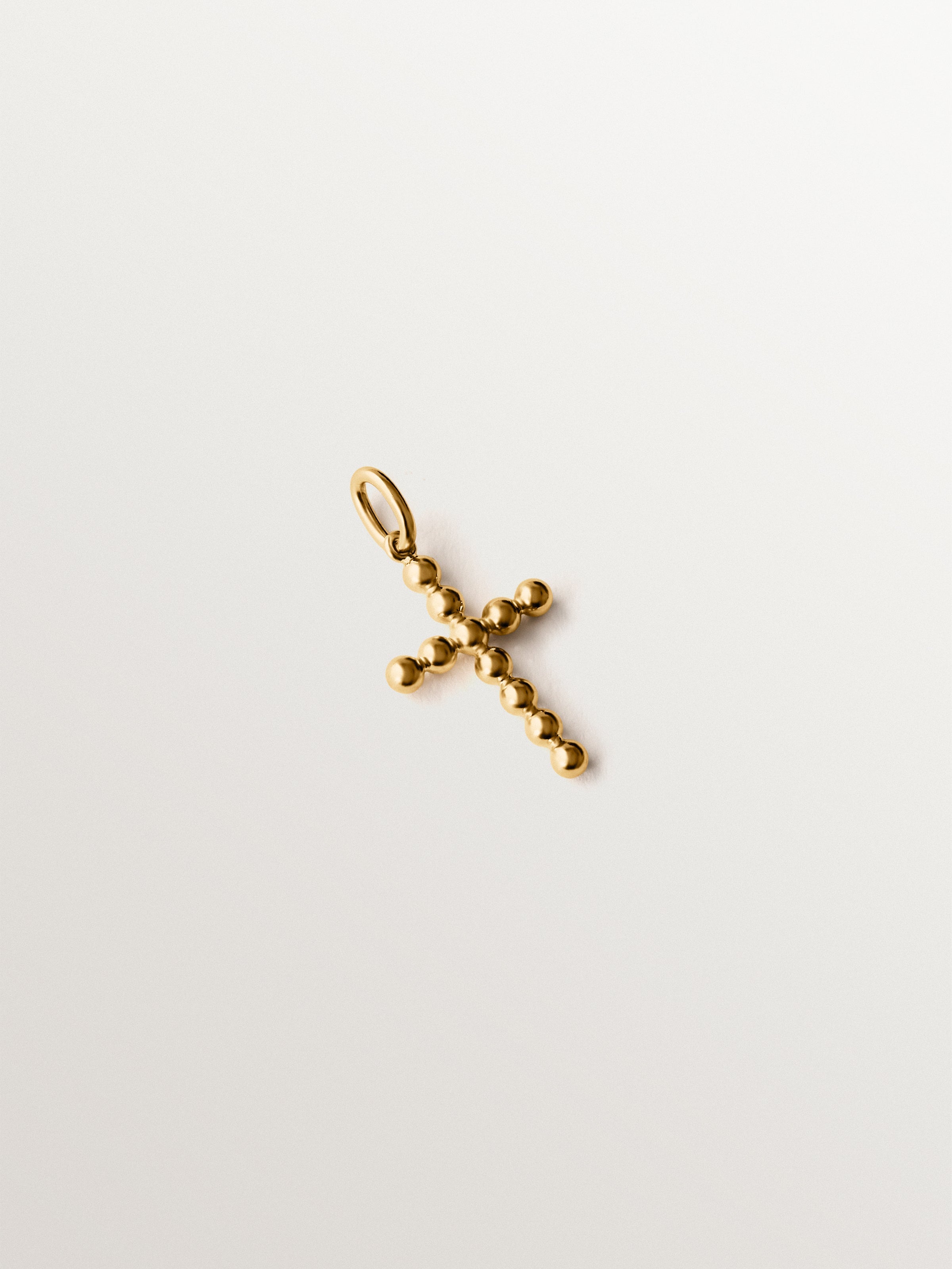Charm de plata 925 bañada en oro amarillo de 18K con forma de cruz y motivos de esferas