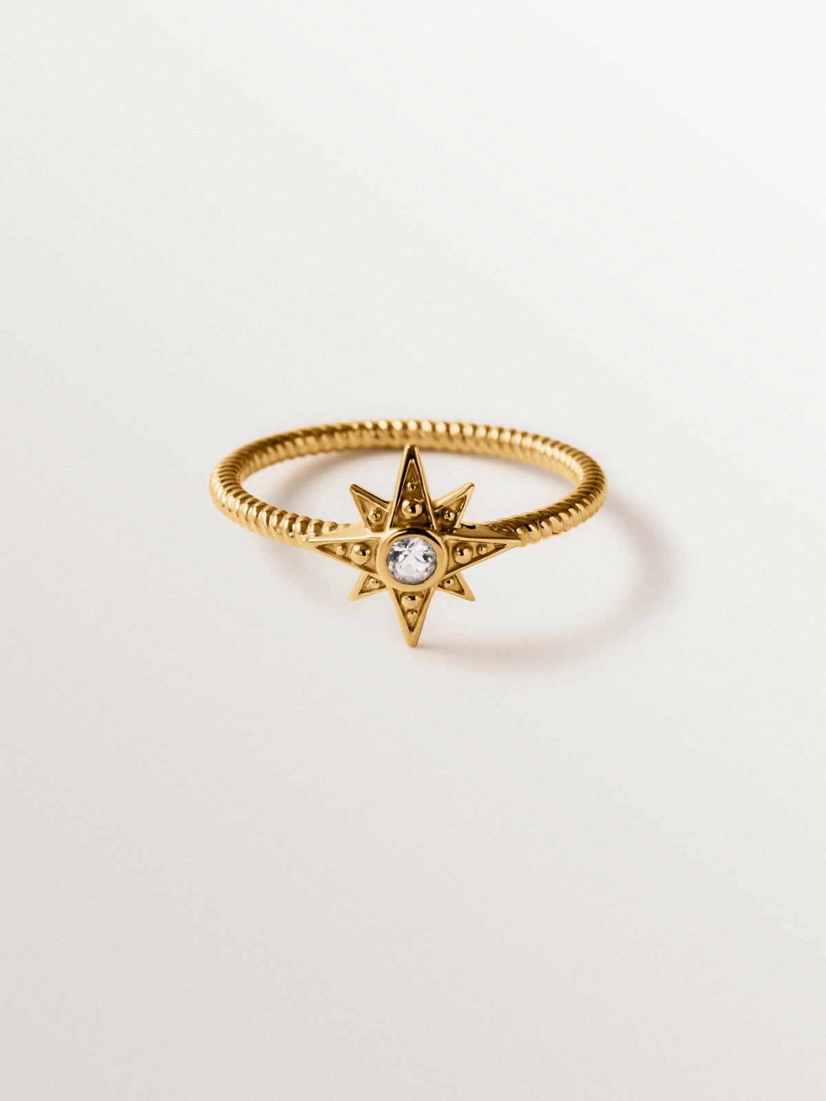 Anillo de plata 925 bañada en oro de 18K con estrella y topacio blanco en textura gallonada