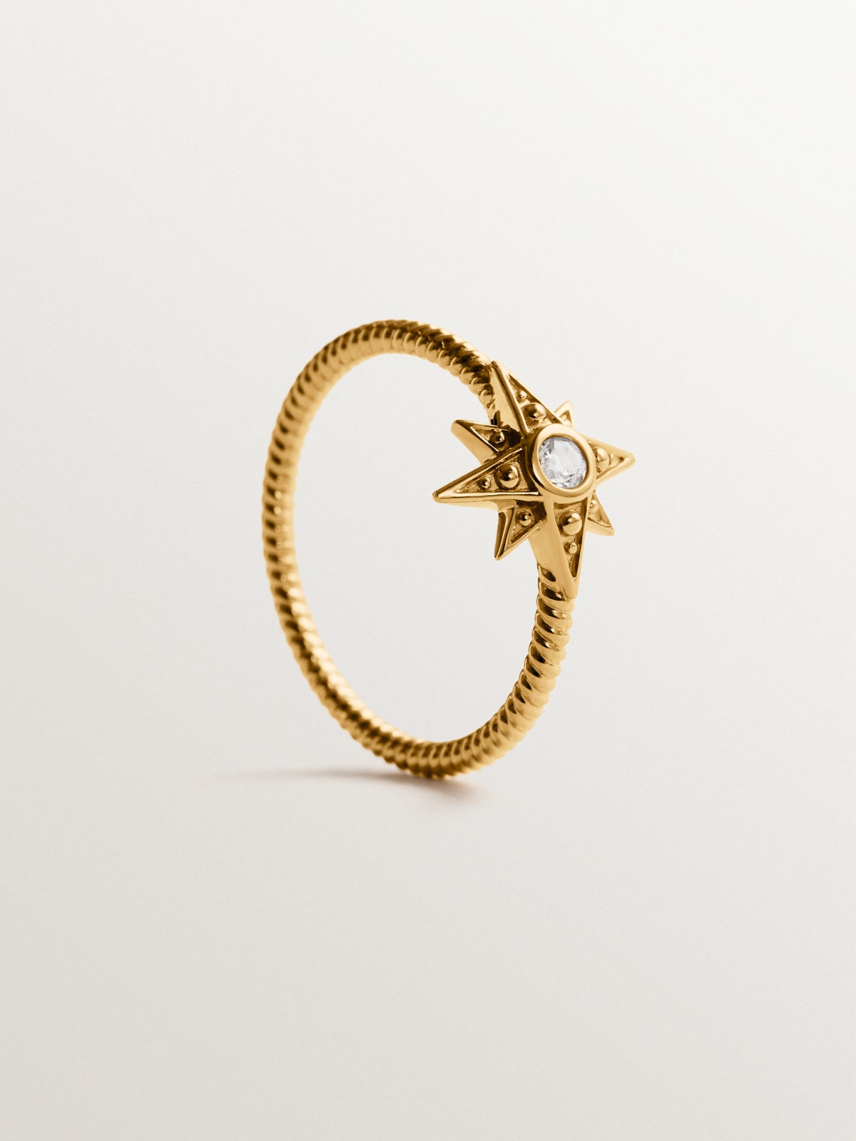 Anillo de plata 925 bañada en oro de 18K con estrella y topacio blanco en textura gallonada