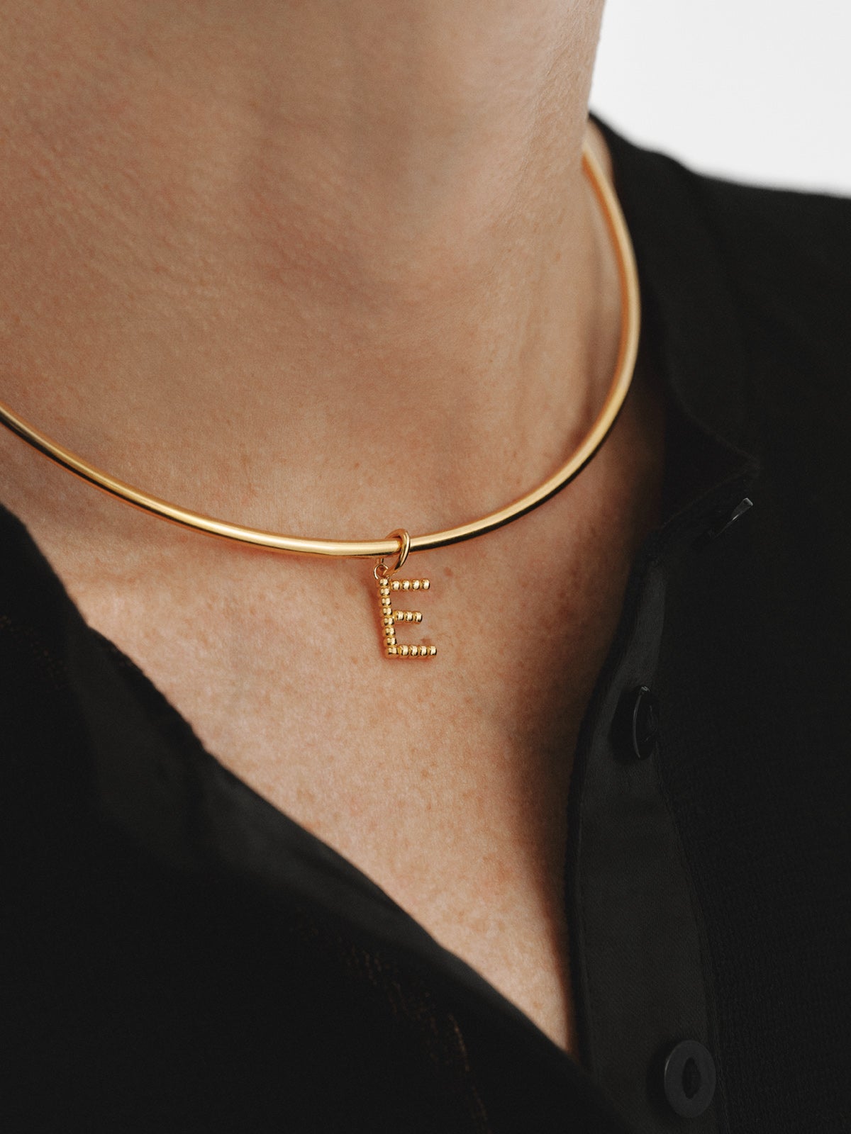 Charm de plata 925 bañada en oro amarillo de 18K con letra E y motivos de esferas