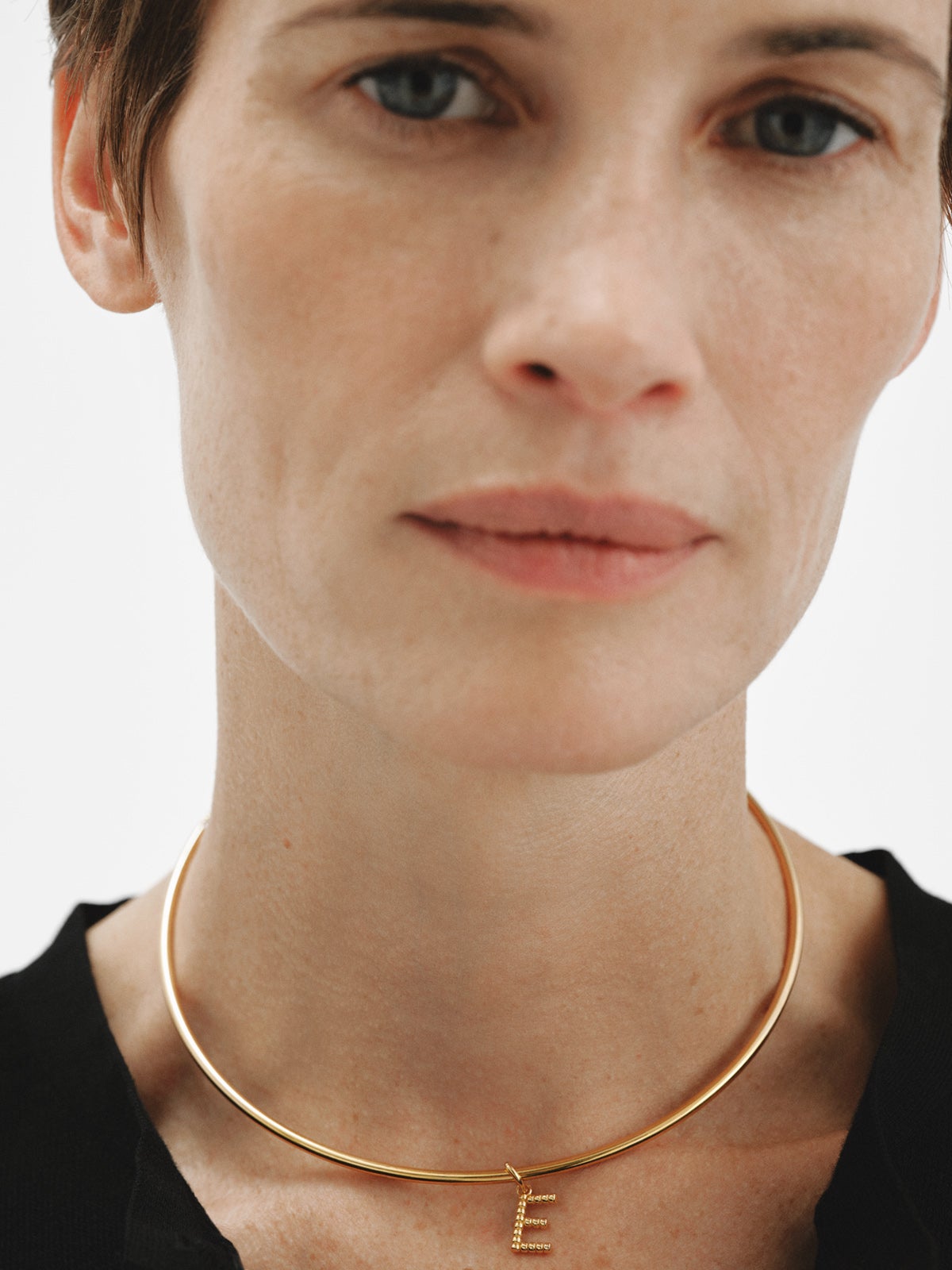 Charm de plata 925 bañada en oro amarillo de 18K con letra E y motivos de esferas