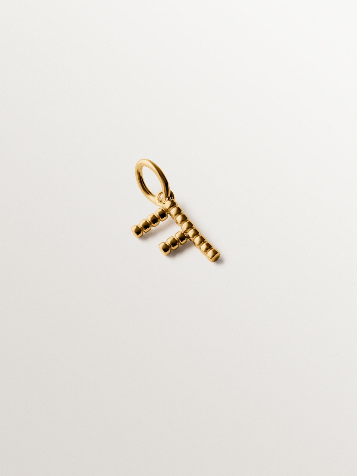 Charm de plata 925 bañada en oro amarillo de 18K con letra F y motivos de esferas
