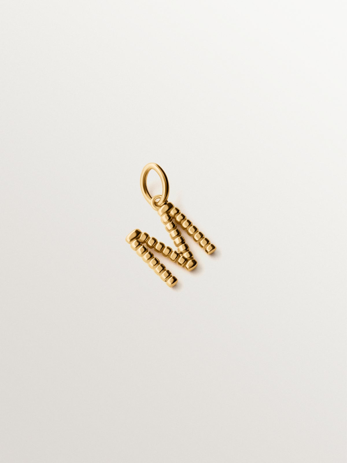 Charm de plata 925 bañada en oro amarillo de 18K con letra M y motivos de esferas