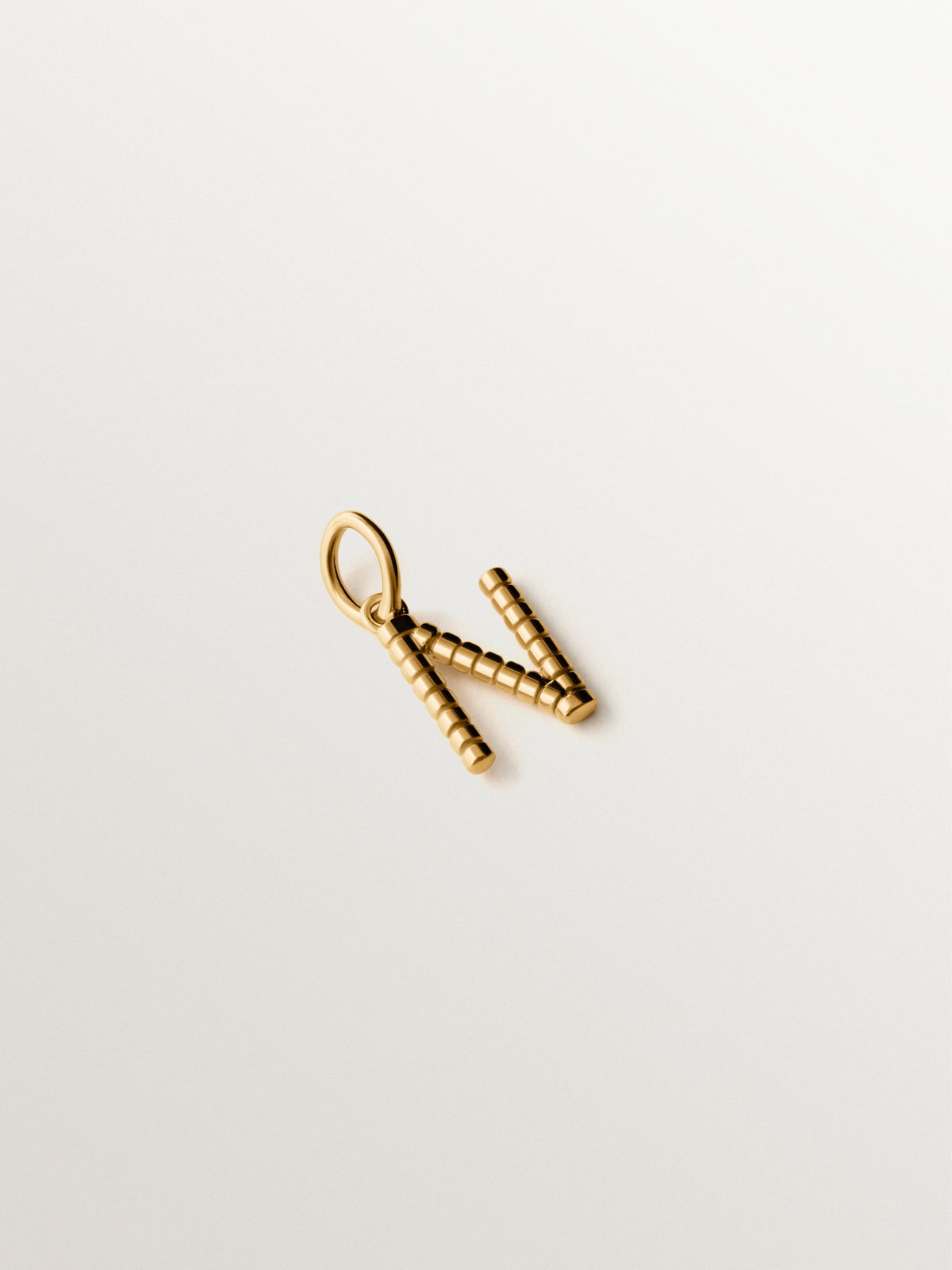 Charm de plata 925 bañada en oro amarillo de 18K con letra N y motivos de esferas