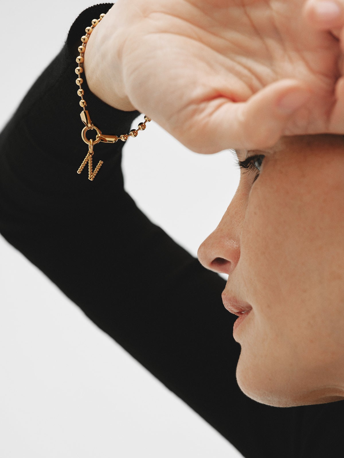 Charm de plata 925 bañada en oro amarillo de 18K con letra N y motivos de esferas