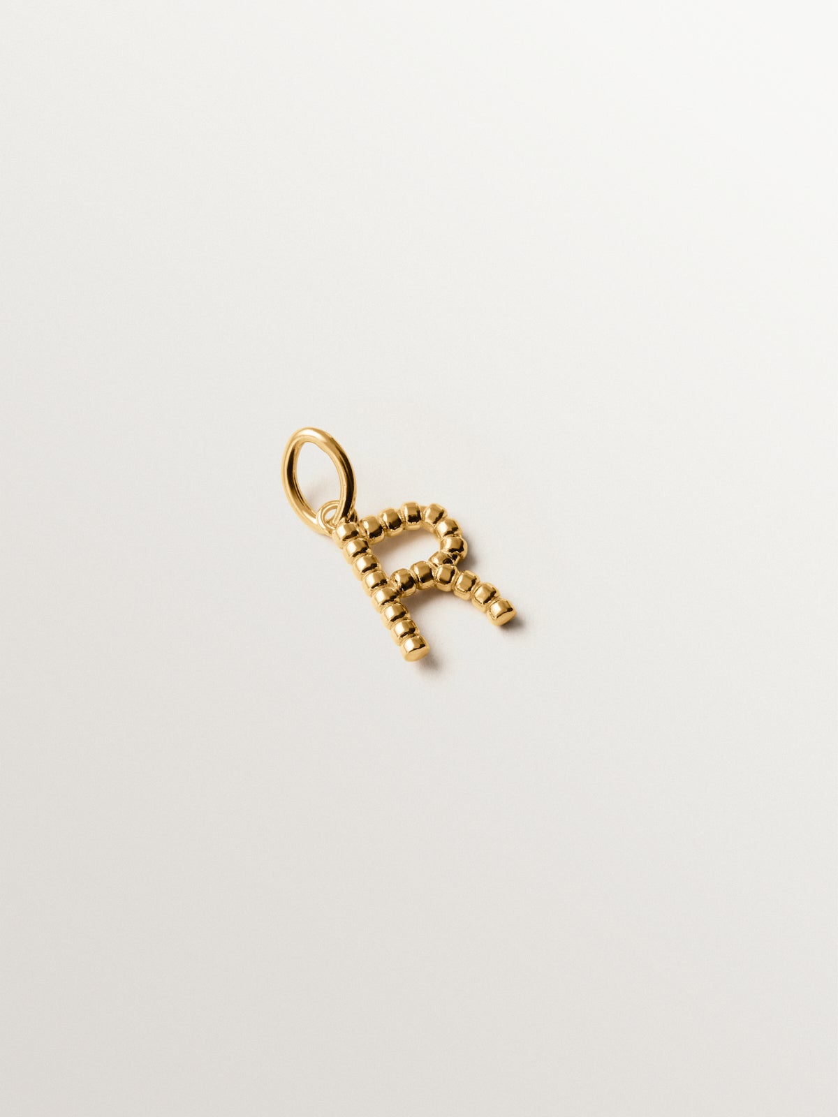 Charm de plata 925 bañada en oro amarillo de 18K con letra R y motivos de esferas