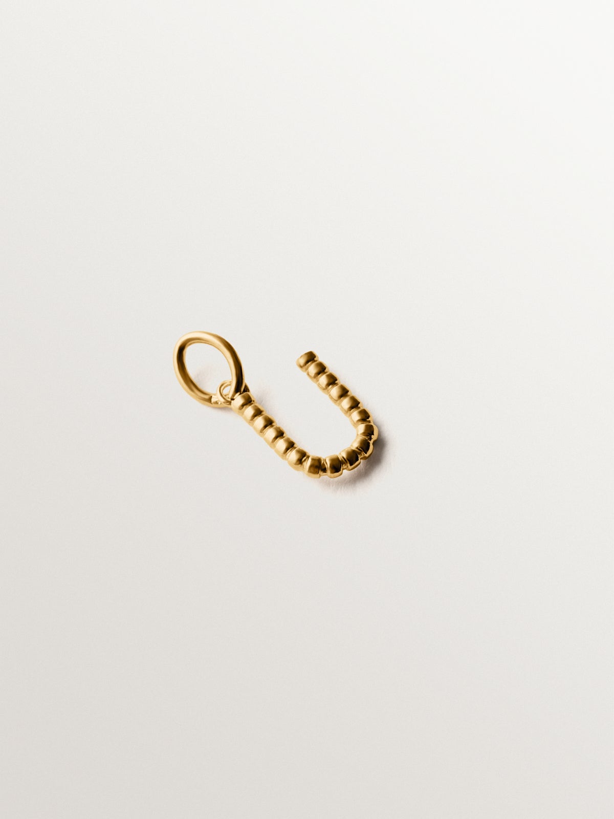 Charm de plata 925 bañada en oro amarillo de 18K con letra U y motivos de esferas