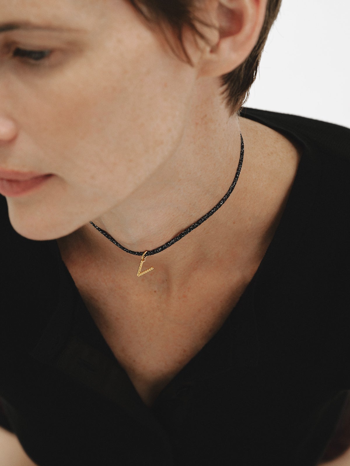 Charm de plata 925 bañada en oro amarillo de 18K con letra V y motivos de esferas