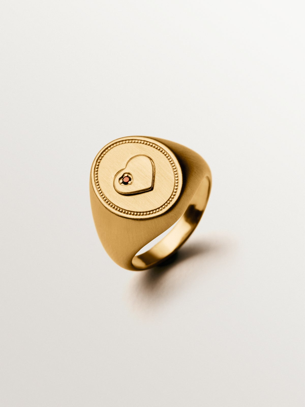 Anillo tipo sello de plata bañada en oro amarillo de 18K con granate rosa