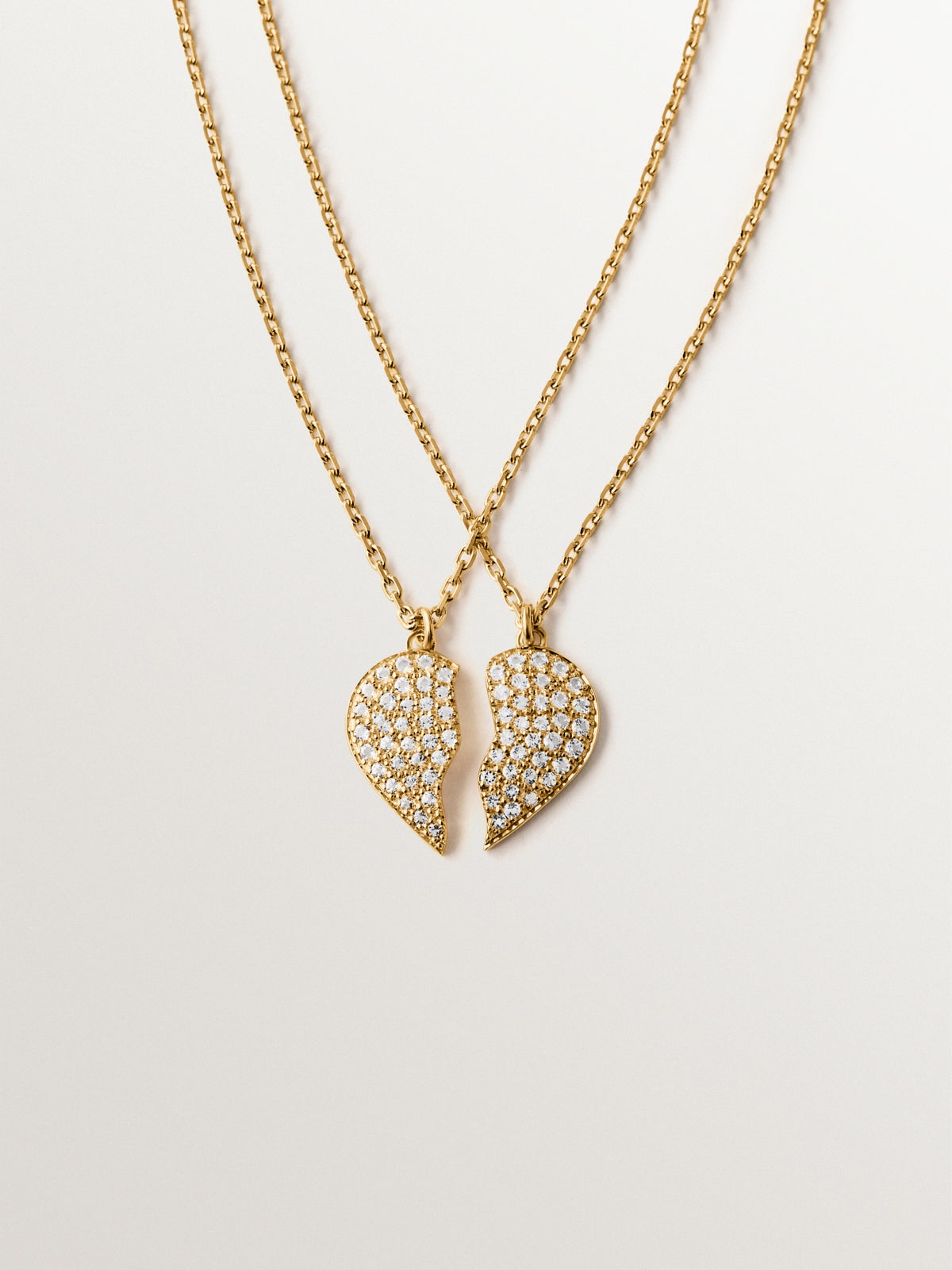 Colgante de plata bañada en oro amarillo de 18K, topacios blancos y forma de corazón partido