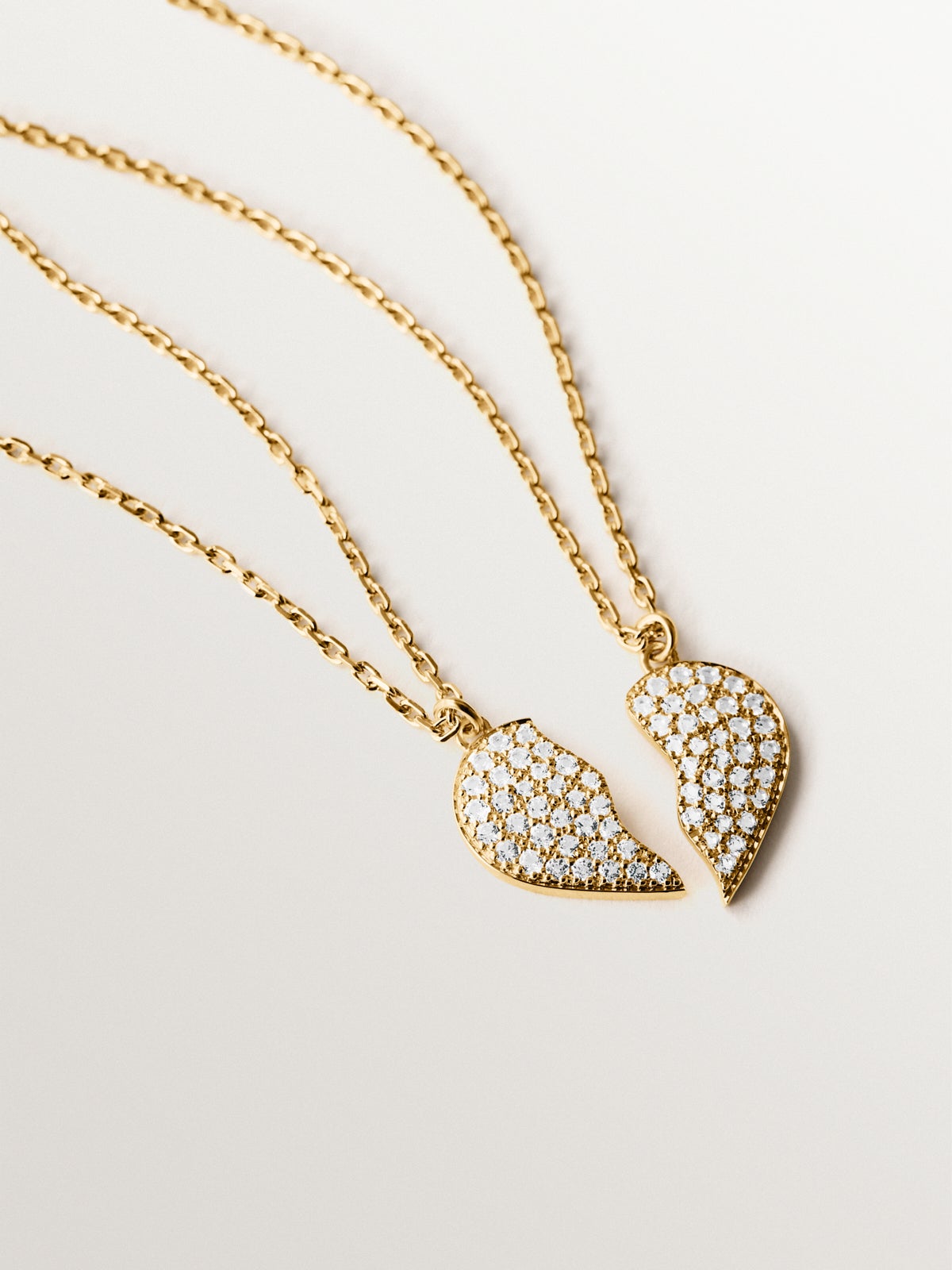 Colgante de plata bañada en oro amarillo de 18K, topacios blancos y forma de corazón partido