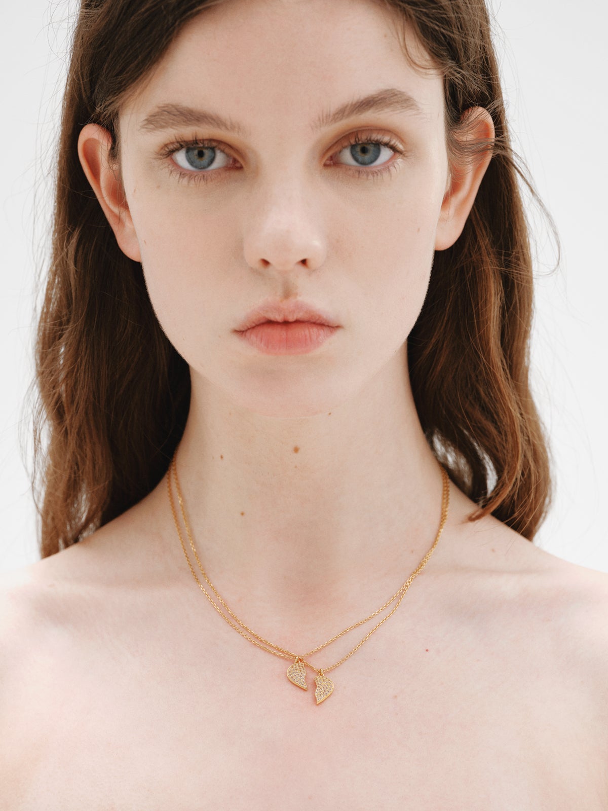 Colgante de plata bañada en oro amarillo de 18K, topacios blancos y forma de corazón partido