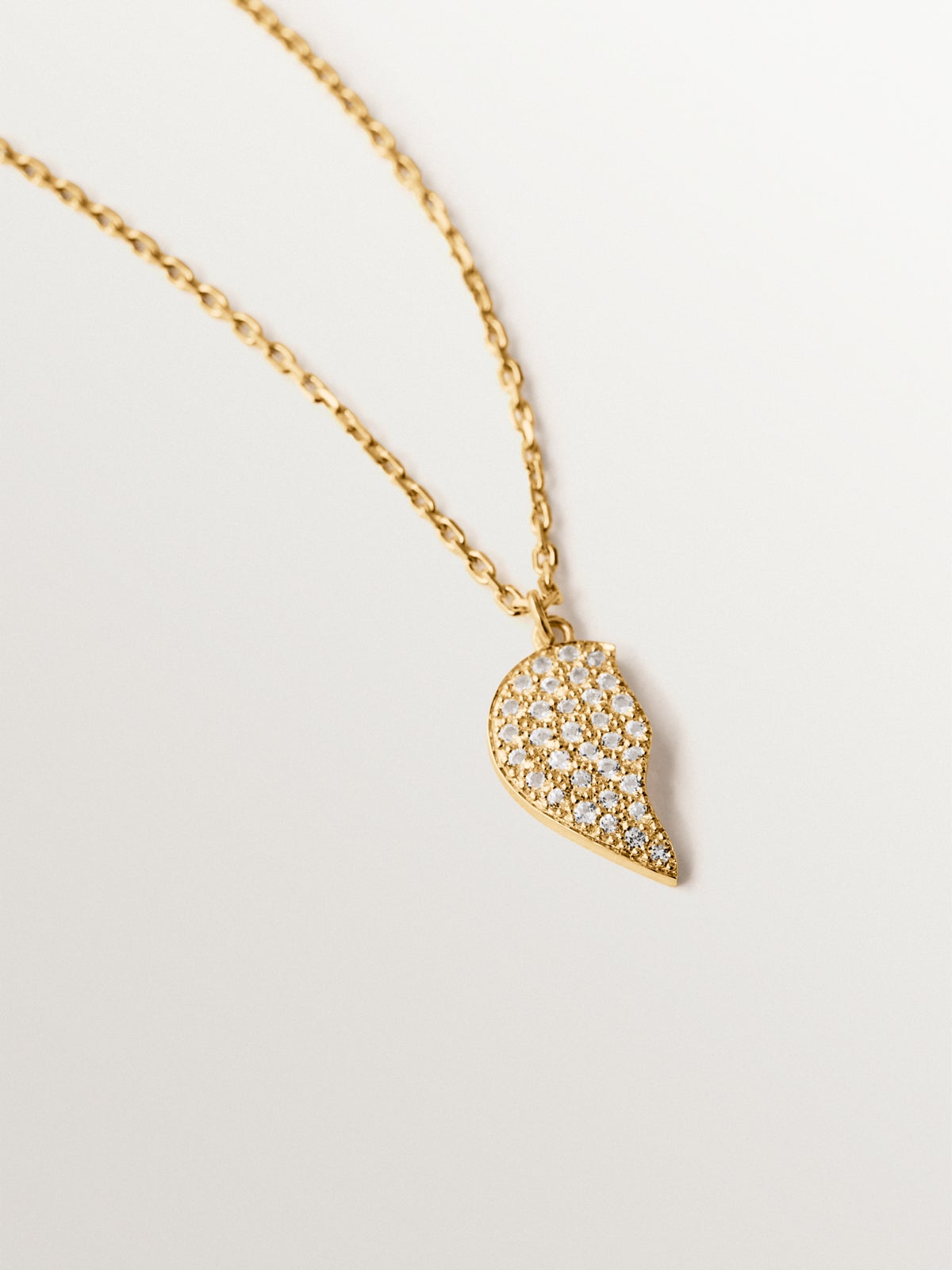 Colgante de plata bañada en oro amarillo de 18K, topacios blancos y forma de corazón partido