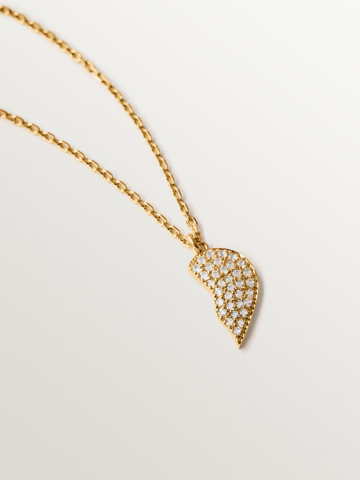 Colgante de plata bañada en oro amarillo de 18K, topacios blancos y forma de corazón partido