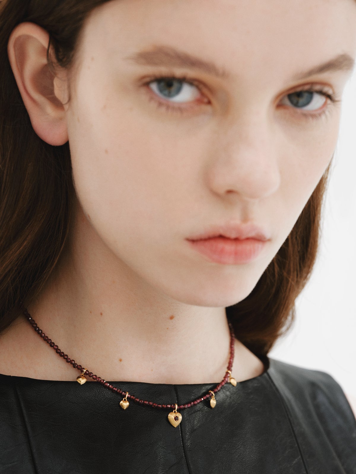 Collar de plata bañada en oro amarillo de 18K con cuentas de granates y motivos de corazón