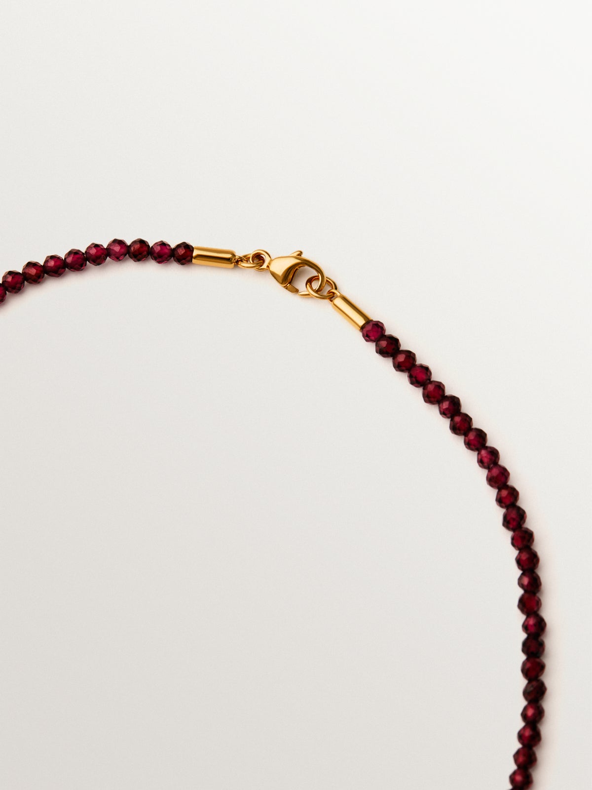 Collar de plata bañada en oro amarillo de 18K con cuentas de granates y motivos de corazón