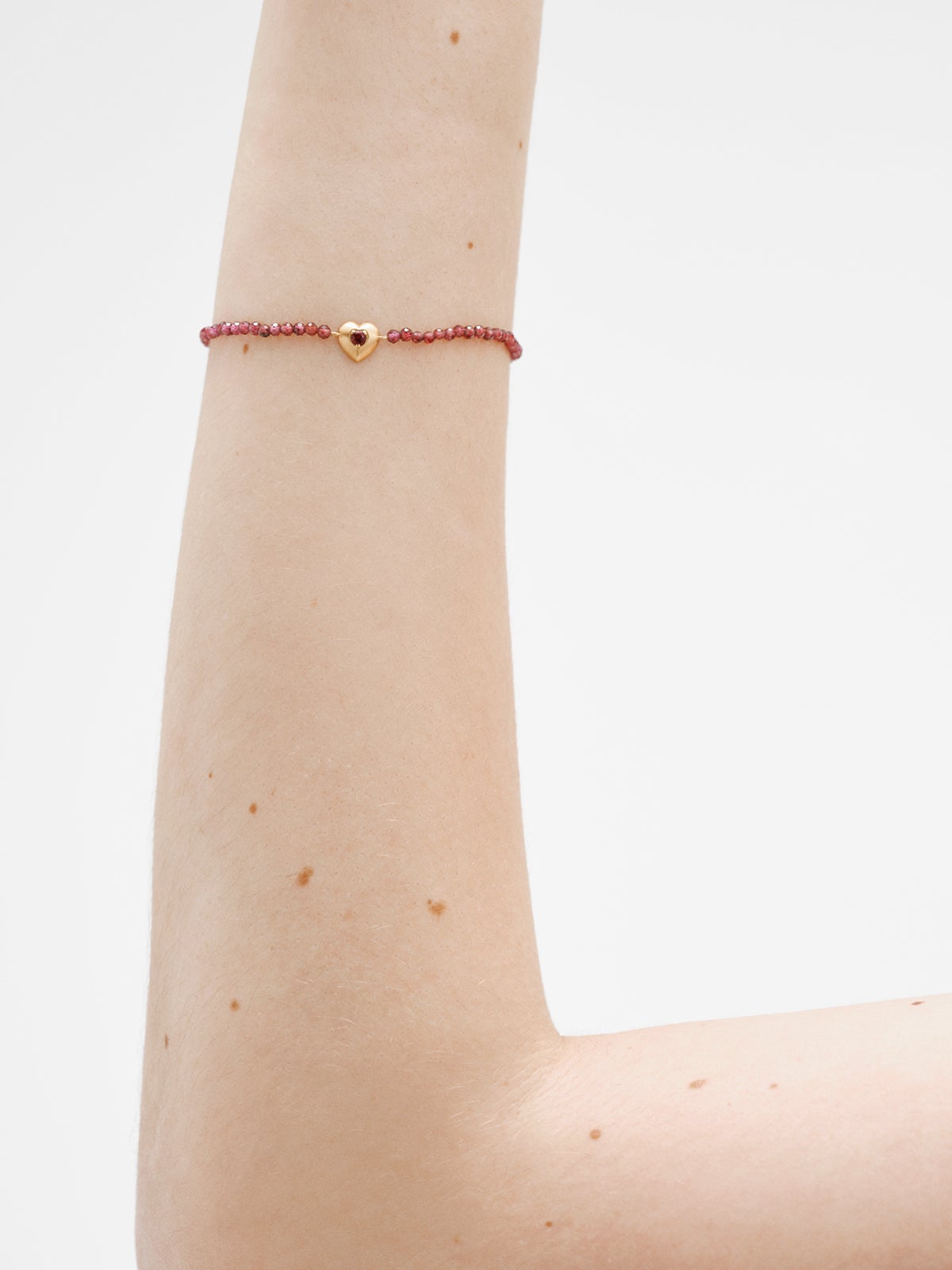 Pulsera de plata bañada en oro amarillo de 18K con cuentas de granates y forma de corazón