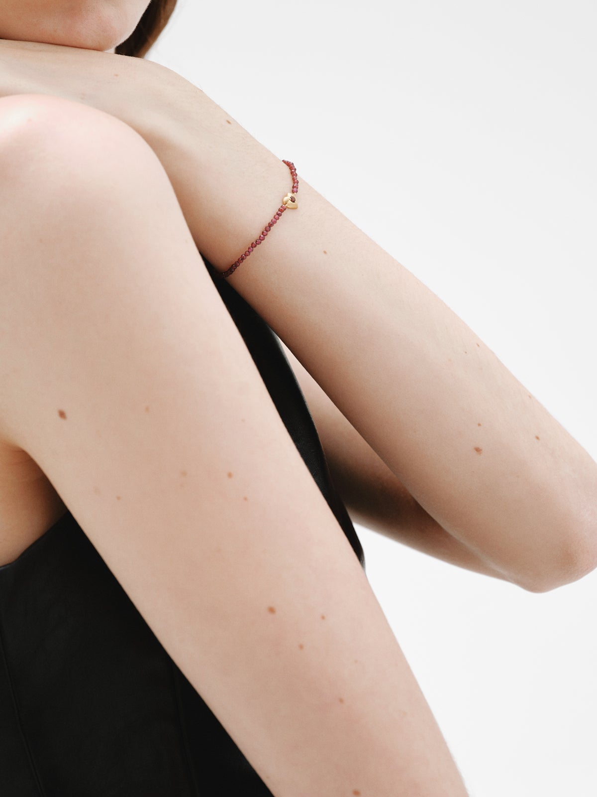 Pulsera de plata bañada en oro amarillo de 18K con cuentas de granates y forma de corazón