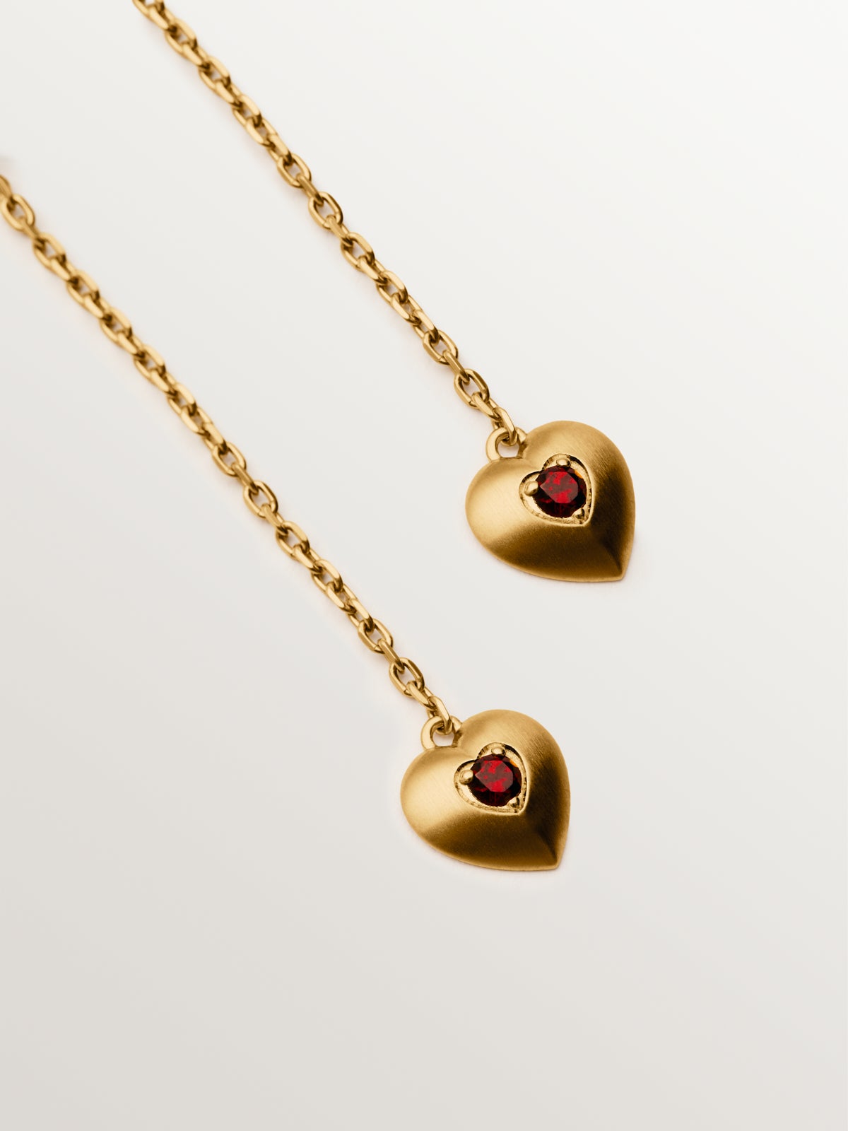 Pendientes largos de plata bañada en oro amarillo de 18K con cuentas de granates rojos, topacios blancos y forma de corazón