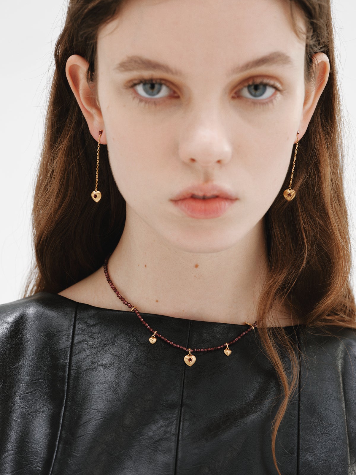 Pendientes largos de plata bañada en oro amarillo de 18K con cuentas de granates rojos, topacios blancos y forma de corazón