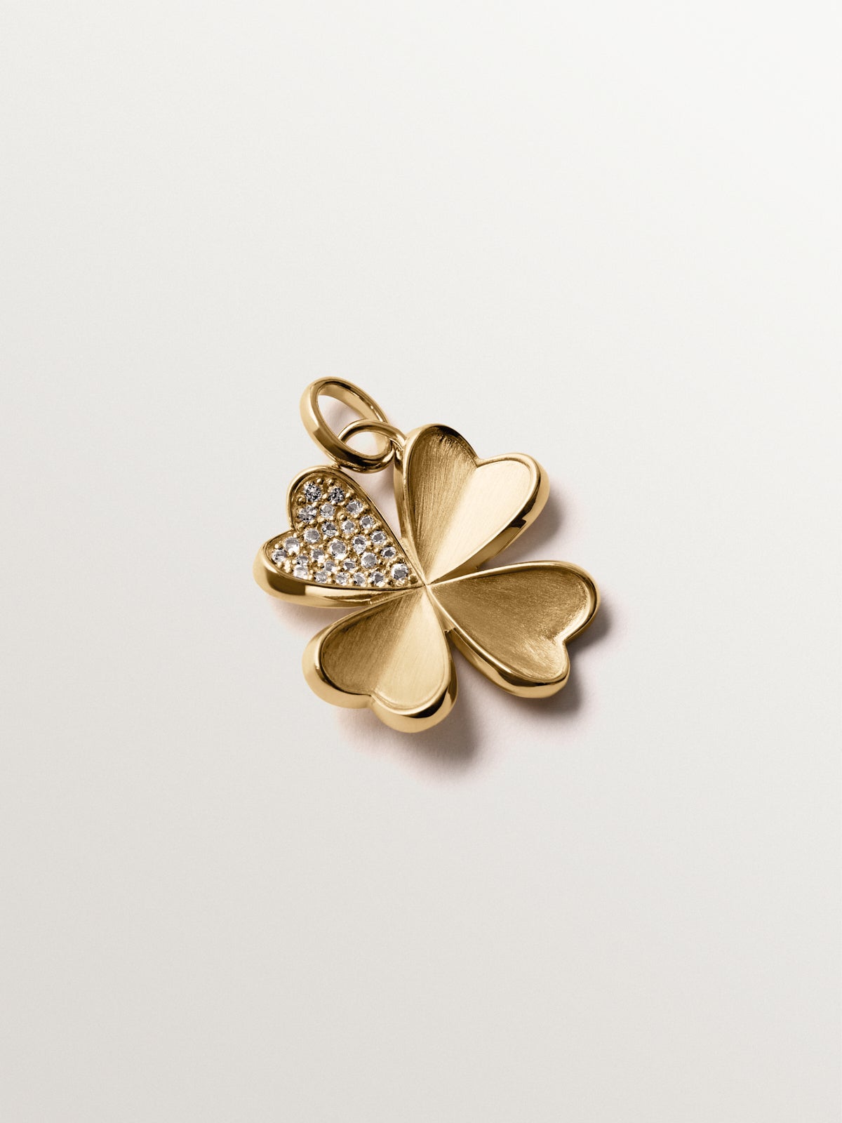 Charm de plata 925 bañada en oro amarillo de 18K con topacios blancos y forma de trébol