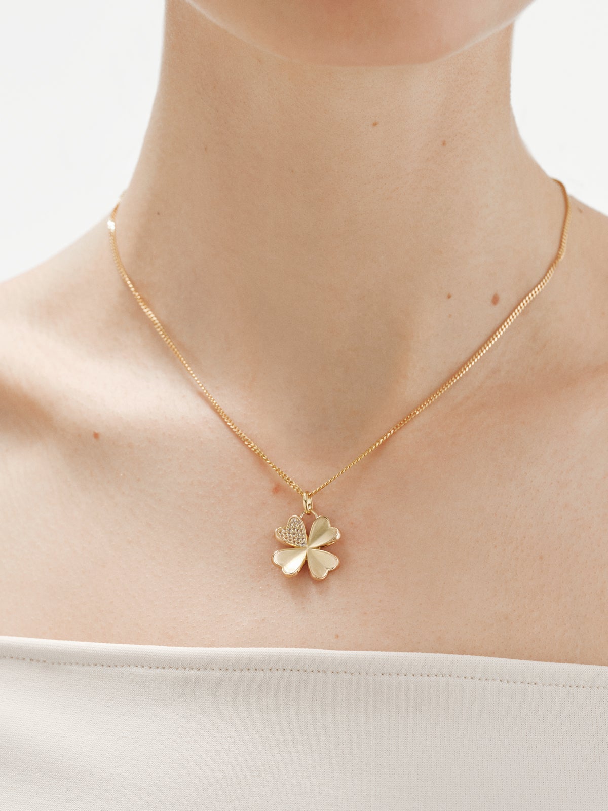 Charm de plata 925 bañada en oro amarillo de 18K con topacios blancos y forma de trébol