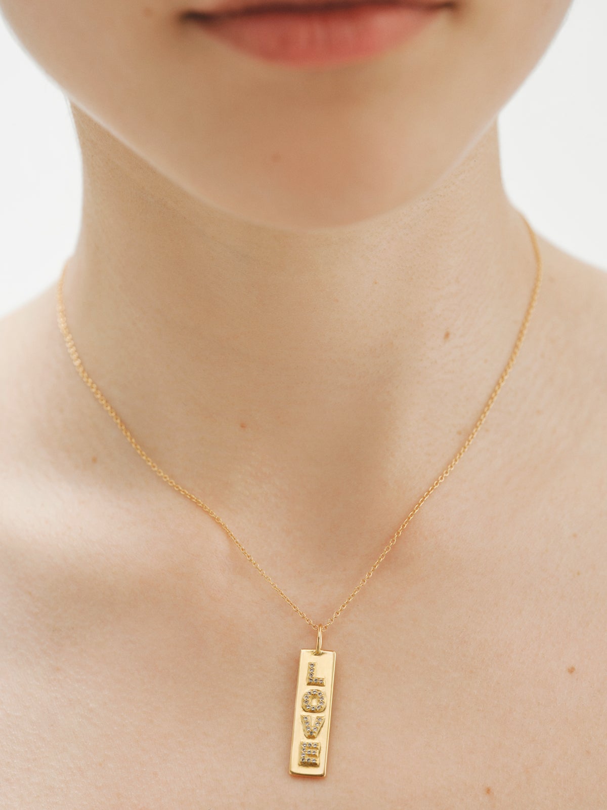 Charm de plata bañada en oro amarillo de 18K Love con topacios blancos