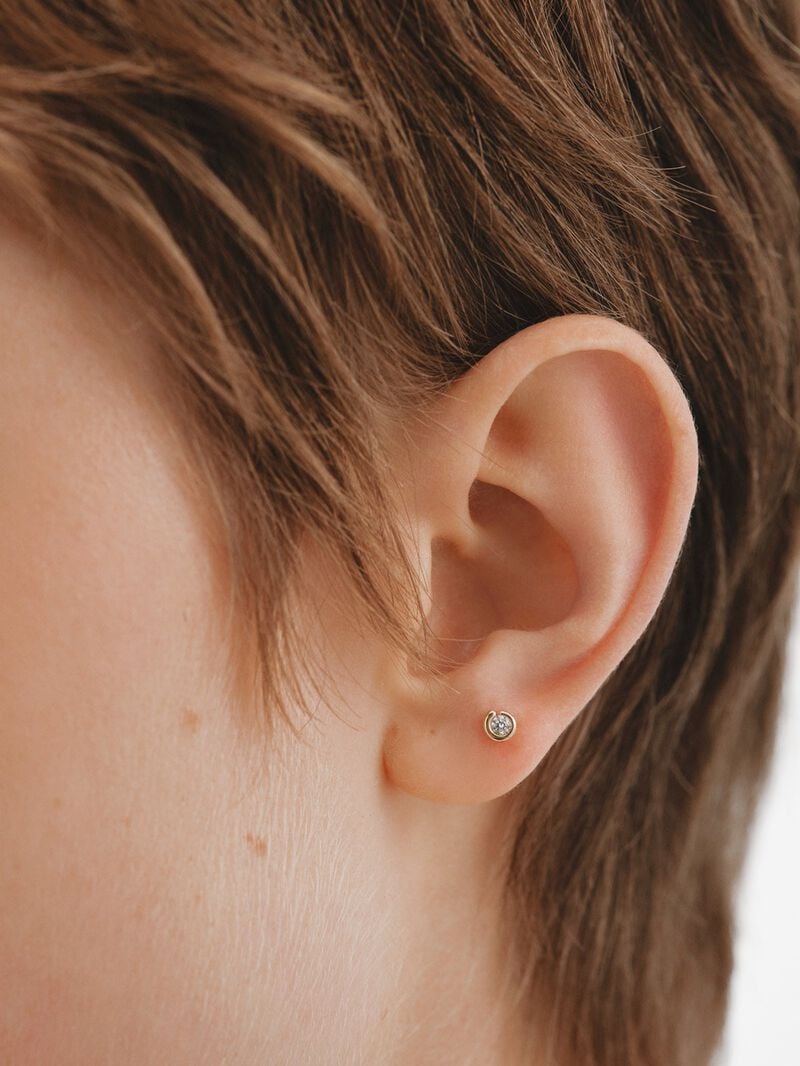 Individual piercing in 18K yellow gold with central brilliant-cut white diamond. image number 1