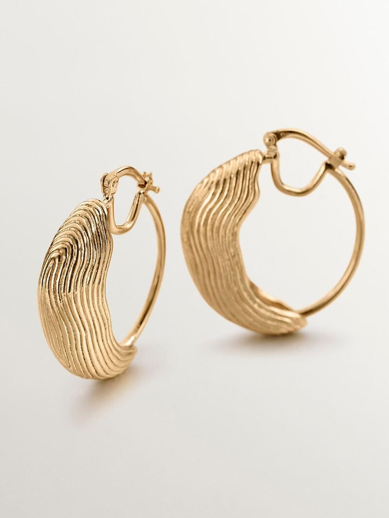 Medium hoop earrings made of 925 silver coated in 18K yellow gold with relief and irregular shape. image number 4