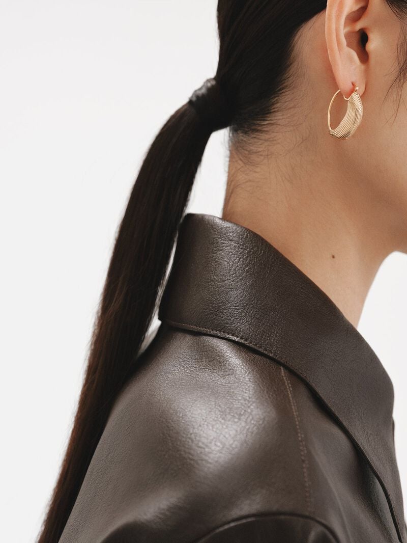 Medium hoop earrings made of 925 silver coated in 18K yellow gold with relief and irregular shape. image number 3