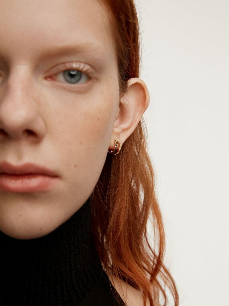 Small double hoop earrings made from 925 silver bathed in 18K yellow gold with embossing and white topazes. image number 1