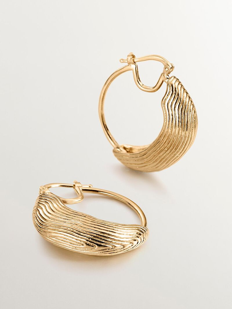 Medium hoop earrings made of 925 silver coated in 18K yellow gold with relief and irregular shape. image number 2