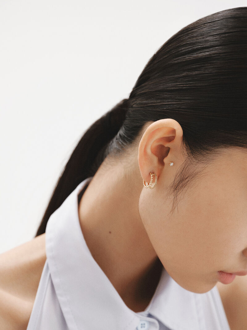 Double hoop earrings made of 925 silver plated in 18K yellow gold with embossing and white topaz. image number 5