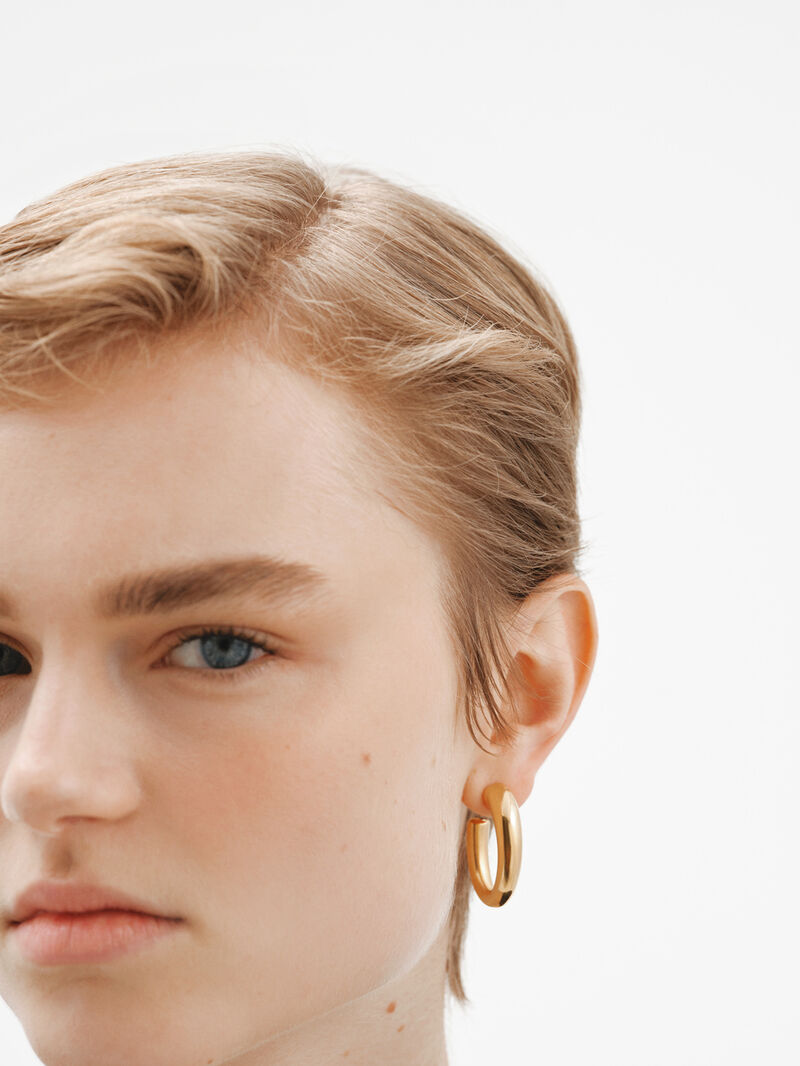Large and thick hoop earrings made of 925 silver, bathed in 18K yellow gold, with an oval shape. image number 1