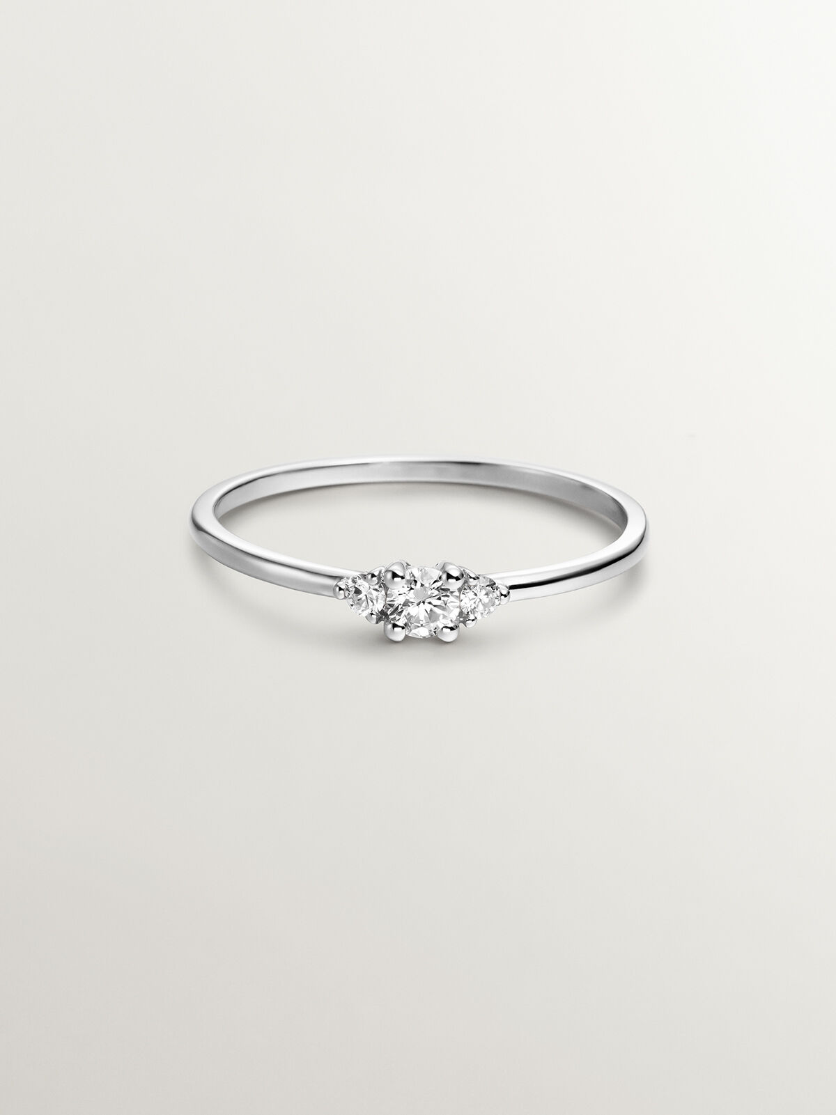 Anillo tresillo de oro blanco de 18K con diamante central de 0