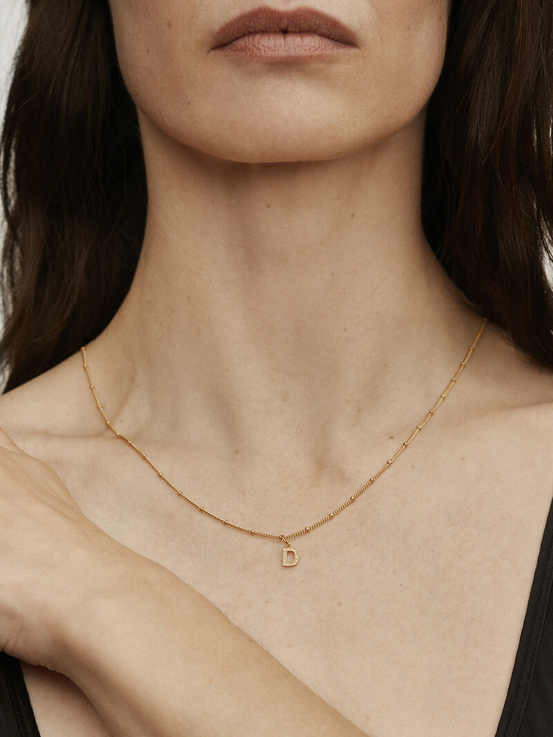 D initial charm made of 925 silver bathed in 18K yellow gold and white topaz. image number 1