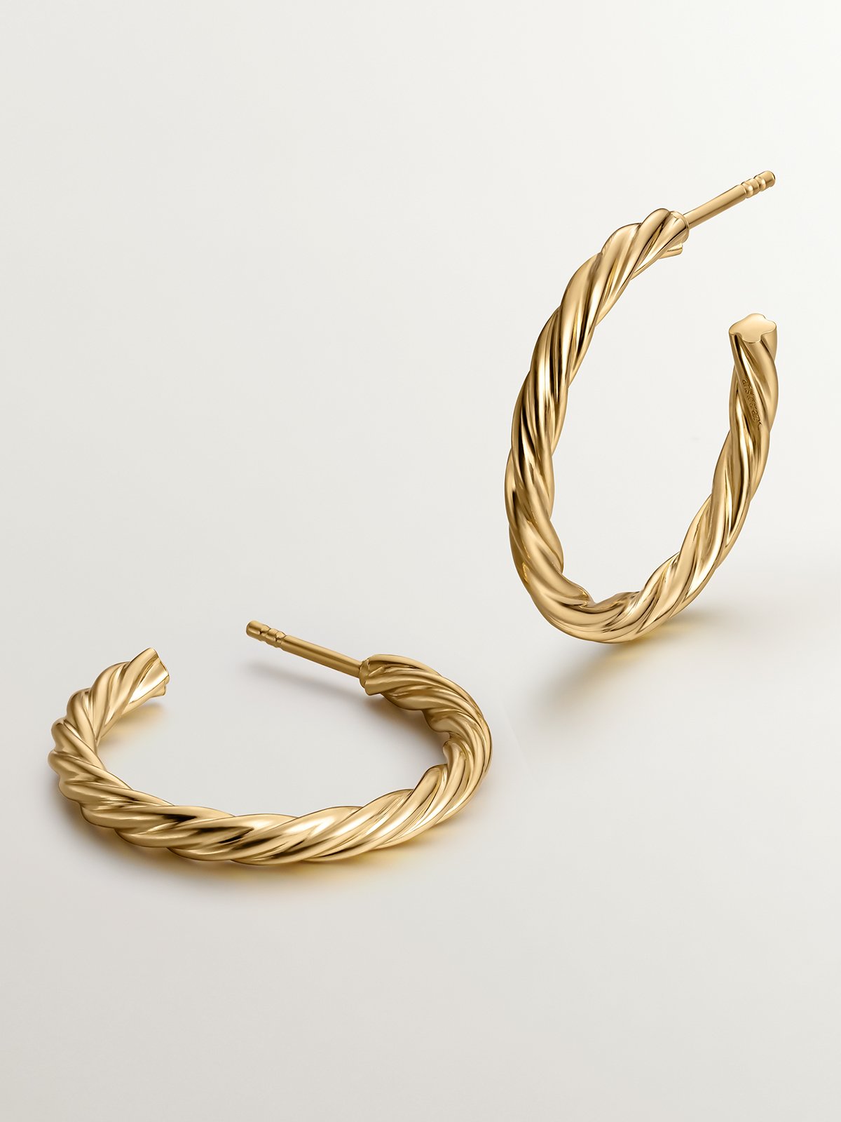 Large hoop earrings made of 925 silver coated in 18K yellow gold with fluted texture.
