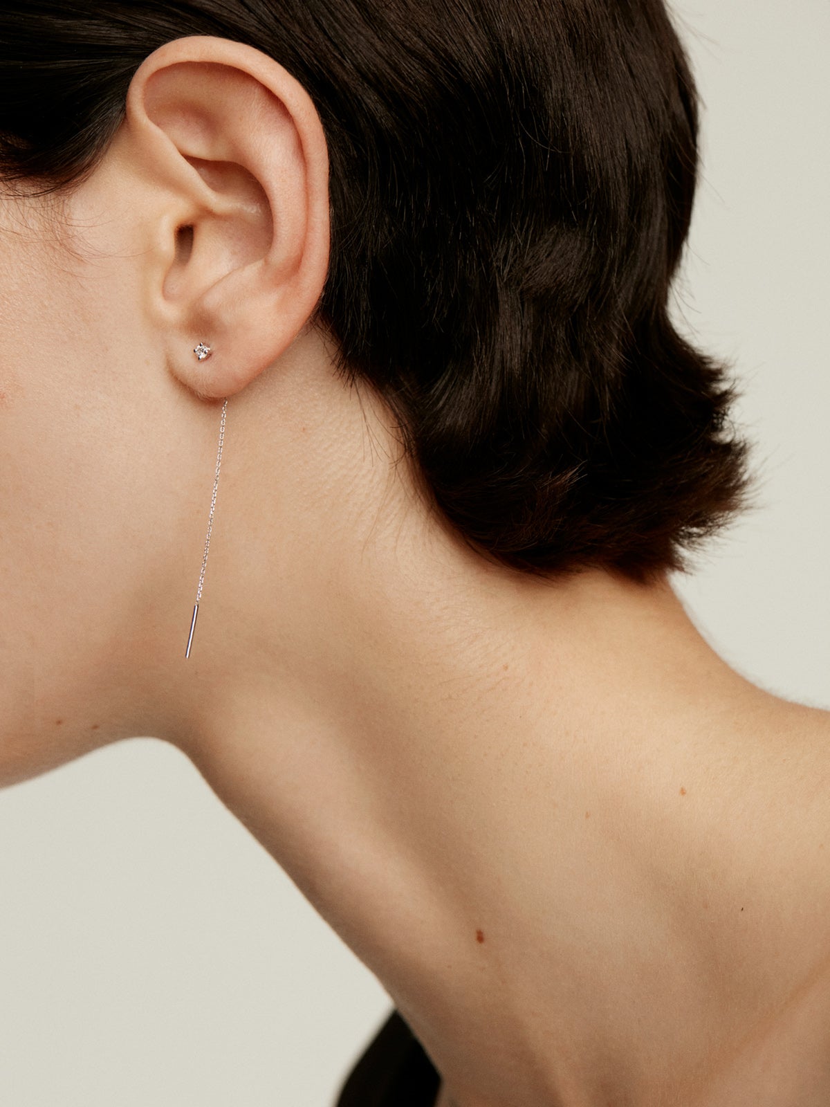 Individual long 18K white gold earring with chain and diamond.