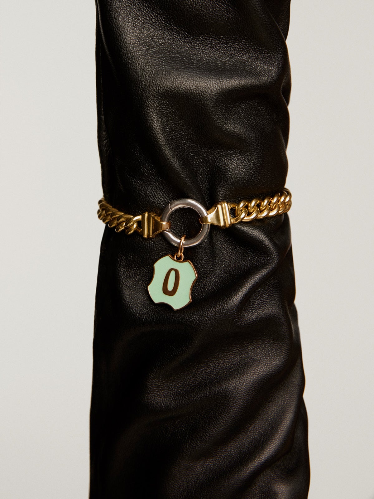 Charm de plata 925 bañada en oro amarillo de 18K con inicial O y esmalte verde con forma irregular