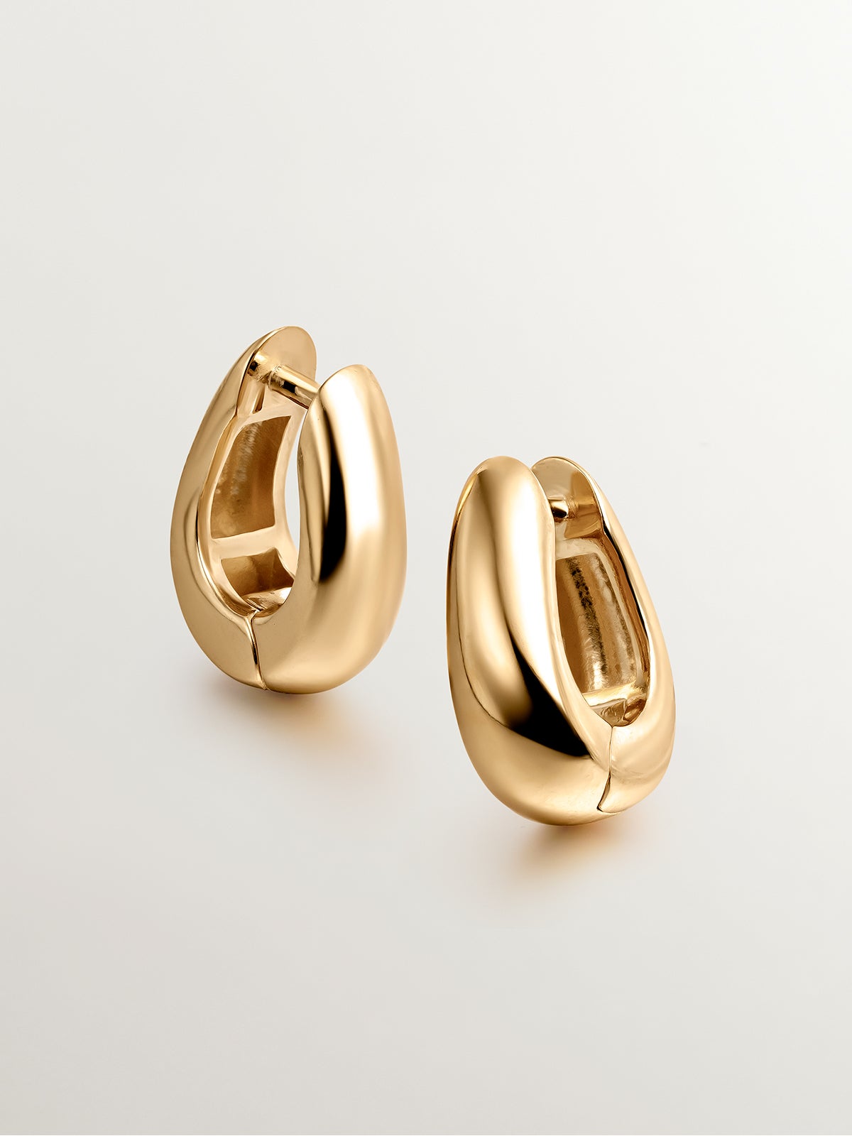 Boucles d'oreilles de créoles moyennes épaisses en argent 925 plaqué or jaune 18K de forme ovale.