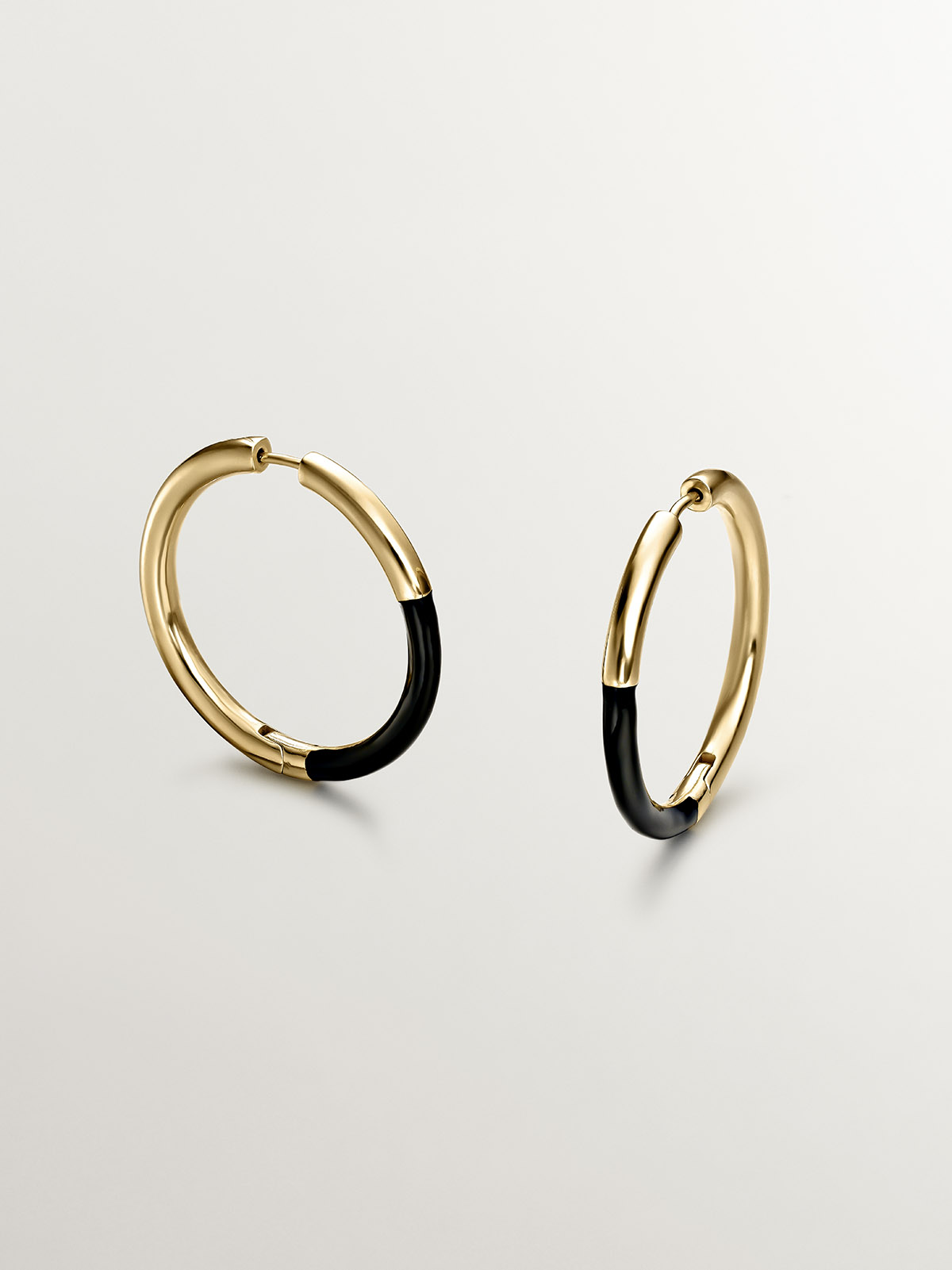 Large hoop earrings made of 925 silver, coated in 18K yellow gold with black enamel